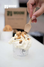 Charger l'image dans la galerie, Main holding a biosourced sugarcane ice cream spoon over a creamy dessert in a cup.