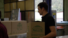 Charger l'image dans la galerie, Worker handling a box of eco-friendly bagasse straws in a production facility.