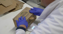 Charger l'image dans la galerie, Person packaging eco-friendly bagasse straws in a brown box for sustainable cocktails.