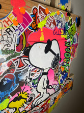 Charger l'image dans la galerie, Oeuvre Pop Art de Snoopy entourée de stickers colorés, ajoutant une touche ludique à la décoration.