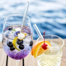 Charger l'image dans la galerie, Verres à cocktails avec pailles courtes en verre borosilicate, garnis de fruits et fleurs, sur une table en extérieur.