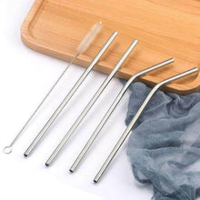 Charger l'image dans la galerie, Set of reusable stainless steel straws in straight and curved designs, with cleaning brush, against wooden tray.