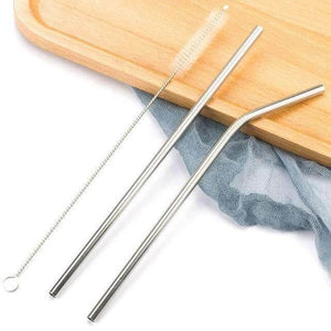 Paille inox droite et courbée avec goupillon sur un plateau en bois, réutilisables et écologiques.